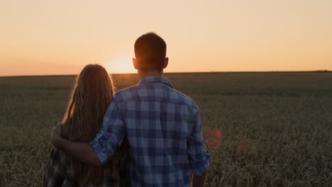 Glückliches-Paar,-Das-Den-Sonnenuntergang-über-Einem-Weizenfeld-Bewundert.-4K-Video