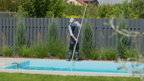 Staff-cleaning-the-pool-with-a-vacuum-cleaner-to-collect-debris-from-the-bottom