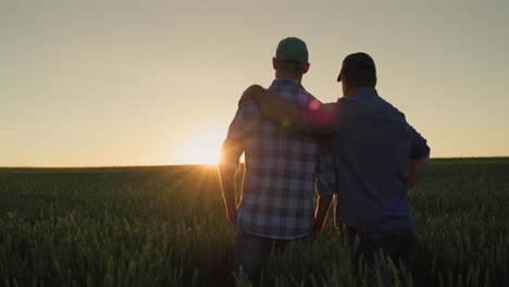 Father-farmer-hugging-his-adult-son-and-watching-the-sunset-over-the-field-together