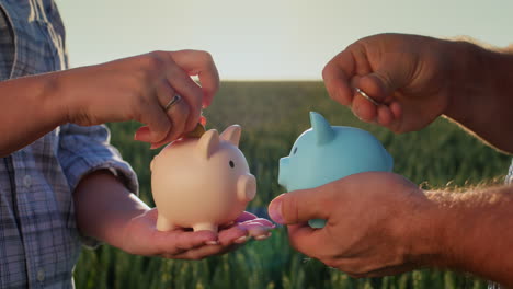 A-man-and-a-woman-each-put-coins-in-their-piggy-bank.-Separate-budget-and-finance
