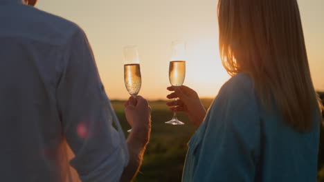 Glückliches-Paar-Mit-Einem-Glas-Rotwein,-Das-Den-Sonnenuntergang-über-Einem-Malerischen-Tal-Beobachtet.-4K-Video