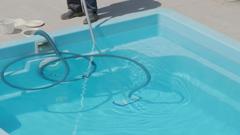 Vacuum-cleaner-for-cleaning-the-pool.-A-worker-removes-pollution-from-the-bottom-of-the-pool,-close-up