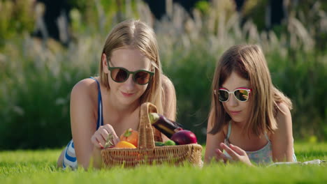 Two-friends-on-a-picnic,-near-them-a-basket-of-fresh-vegetables