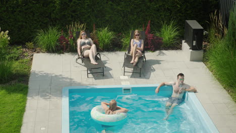 Familie-Entspannt-Am-Pool-Und-Erholt-Sich-An-Einem-Heißen-Sommertag