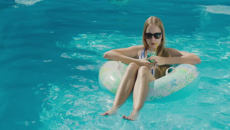 Ein-Junges-Mädchen-Schwimmt-In-Einem-Aufblasbaren-Kreis-Auf-Der-Oberfläche-Des-Pools