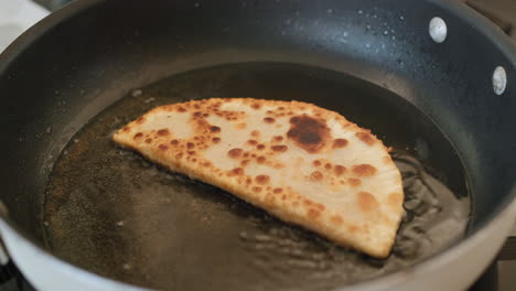 Cheburek-is-fried-in-oil-in-a-frying-pan