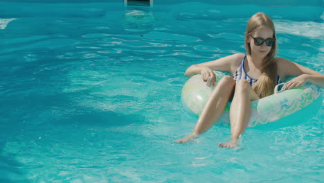 Ein-Junges-Mädchen-Schwimmt-In-Einem-Aufblasbaren-Kreis-Auf-Der-Oberfläche-Des-Pools