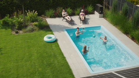 A-cheerful-family-relaxes-in-the-pool-in-the-backyard-of-a-villa.-Hot-summer-day