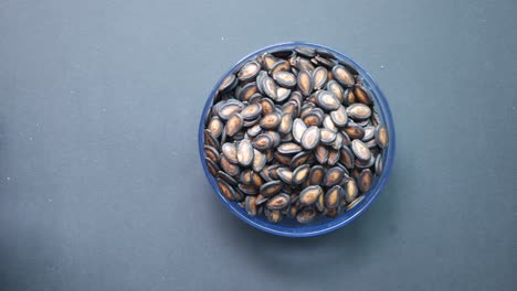 Top-view-of-melon-seeds-in-a-bowl-on-black-background