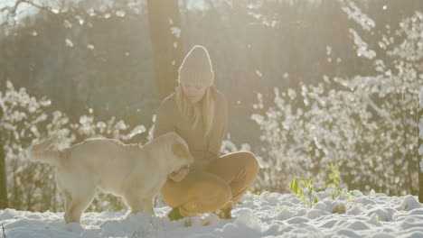 Young-woman-walking-with-a-dog-in-a-winter-park