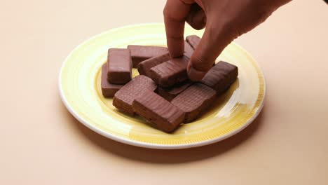 Hand-pick-dark-chocolate-from-a-plate-,