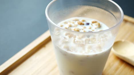 Breakfast-cereal-and-milk-in-a-glass-on-table-,