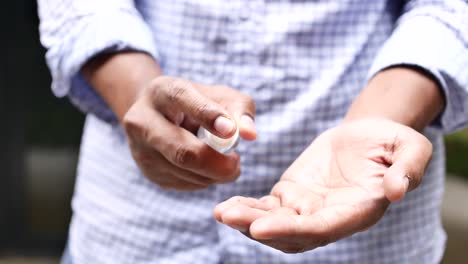 Close-up-of-young-man-hand-using-hand-sanitizer-spray