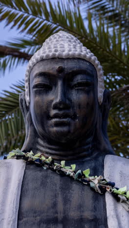 Buddha-Statue-Mit-Palmen-Dahinter-In-Vertikaler