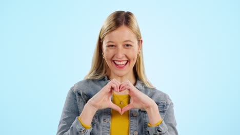 Heart,-hands-and-face-of-happy-woman-in-studio