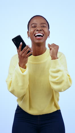 African-woman,-phone-and-celebration-in-studio