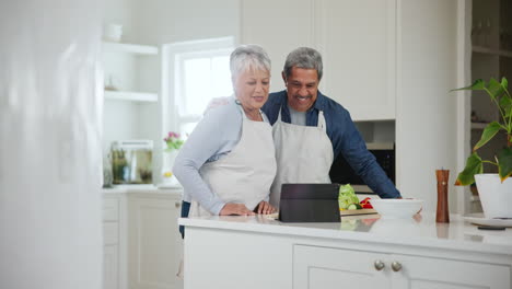 Kitchen,-greeting-and-senior-couple-with-a-tablet