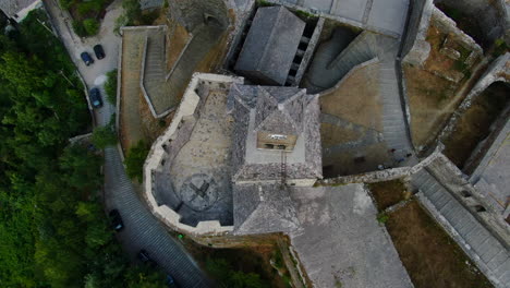 Cenital-Drone-shot-4k-of-clock-of-Gjirokastra-castleGjirokastra-Castle-is-a-castle-in-Gjirokastra,-Albania