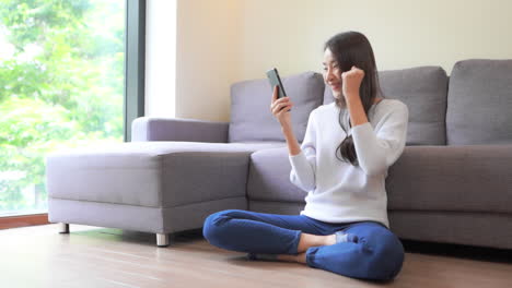 Casual,-Happy-Asian-Girl-Cheering-when-Using-Smartphone