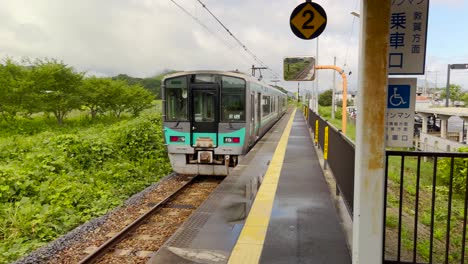 Pan-from-left-to-right-following-a-local-train-departing-a-rural-station-in-Japan