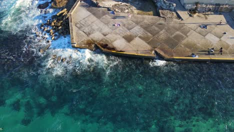 Tourists-At-Tom-Caddy-Point-Looking-At-The-Clear-Water-Of-Clovelly-Bay-In-Sydney-Australia-During-Sunny-Day