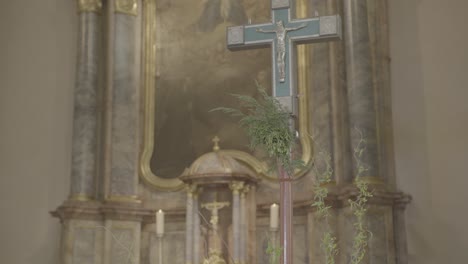 Camera-pans-to-a-cross-in-the-sanctuary-of-a-church-with-a-baroque-altar-in-the-background