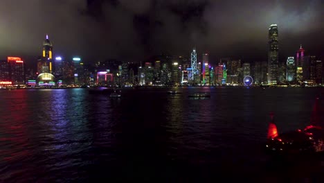 Aerial-View,-Hong-Kong-Night-Cityscape-Panorama-and-Waterfront,-Shiny-Buildings-on-Bay,-Drone-Shot