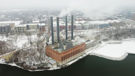 Steam-Power-Plant-in-Winter-Along-River,-Fixed-Aerial-View