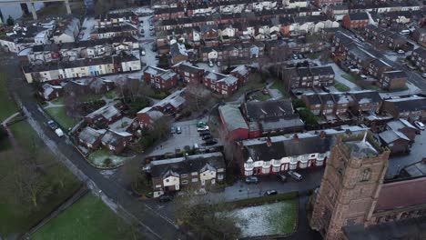 Aerial-birdseye-right-above-industrial-small-town-frosty-church-rooftops-neighbourhood-North-West-England