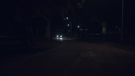 Pavement-Road-With-Bright-Headlights-Of-Car-Approaching-At-Night