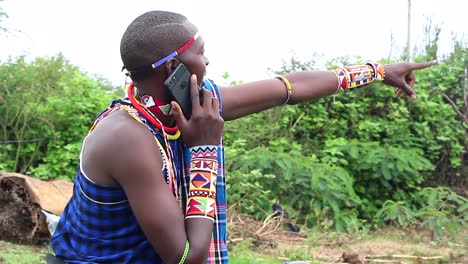 Maasai-man-on-phone-pointing-his-finger-at-subject-of-interest