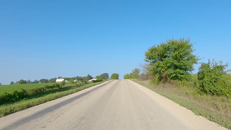 POV-while-driving-past-fields-and-farms-on-a-gravel-road-in-rural-Iowa-in-late-summer