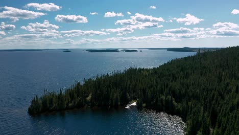 Drone-flying-over-an-isolated-dock-in-a-large-forest-and-lake