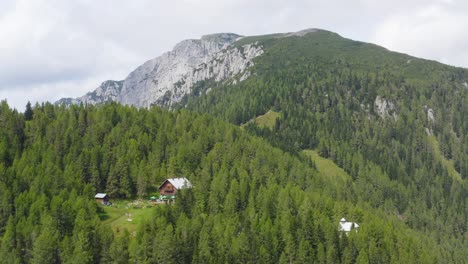 Luftdrohne-Malerische-Aussicht-Auf-Die-Berge-Mit-Berghütte-Im-Vordergrund
