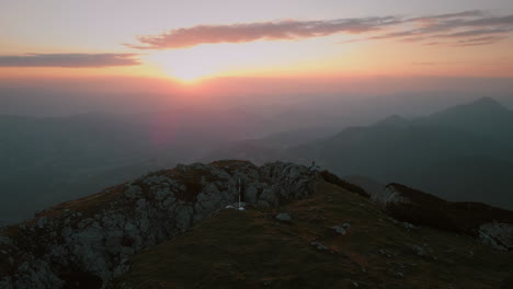 Drohnenschuss,-Der-Es-Am-Frühen-Morgen-Mit-Einem-Orangefarbenen-Sonnenaufgang-Von-Der-Spitze-Des-Berges-Peca-Distanziert