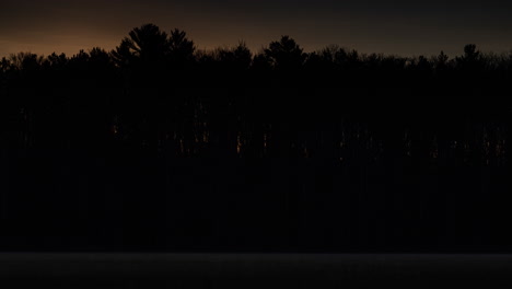 Time-lapse-of-sunrise-through-the-trees-on-the-far-side-of-a-small-lake-in-northern-Michigan