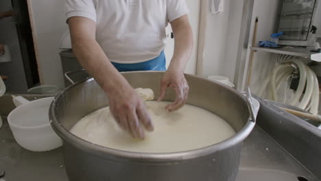 A-cheesemaker-in-Italy-pulling-and-folding-and-stretching-a-large-batch-of-mozzarella