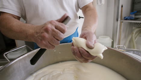 A-cheese-maker-in-Italy-cutting-a-ball-of-mozzarella-into-the-shape-of-a-cow