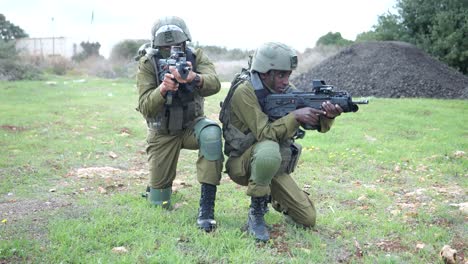 Two-IDF-Israel-Army-Infantrymen-Soldiers-in-a-Kneeling-Position-Level-Machine-Guns-At-Rural-Area-of-Training-Ground---orbit-shot