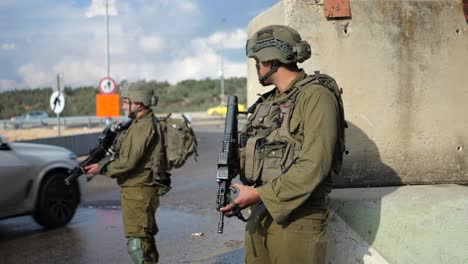 IDF-Armored-Soldiers-in-Uniform-with-Machine-Guns-at-Roadblock-Checkpoint-Controlling-Traffic-Daytime