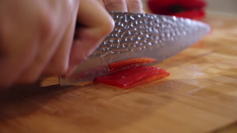 El-Chef-Corta-Pimiento-Rojo-Grande-En-La-Tabla-De-Cortar,-En-La-Cocina