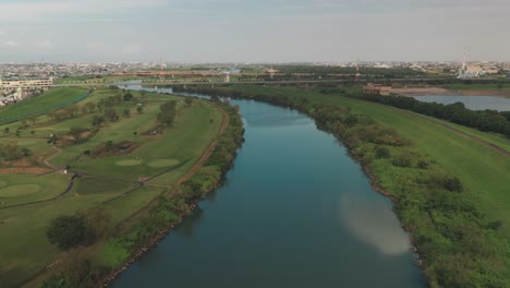 Calm-Waters-At-Arakawa-River-With-A-Golf-Course-On-The-Left-Side-In-Saitama,-Japan