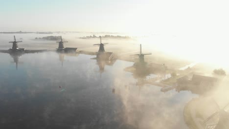 Dutch-windmills-surrounded-by-low-fog-on-a-epic-golden-hour-at-the-zaanse-schans-Cinematic-Drone-Aerial-in-4K