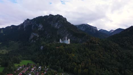 Drone-flying-to-Castle-Neuschwanstein-and-mountains-in-Bavaria,-Germany-in-4k
