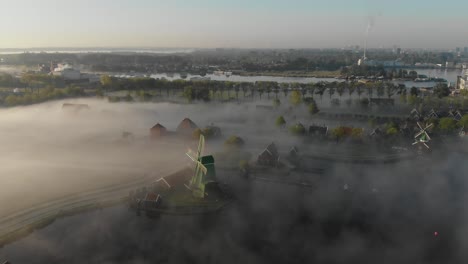 Die-Zaanse-Schans-An-Einem-Frühen-Morgen-Mit-Niedrigem-Nebel,-Filmische-Drohnenantenne-In-4K