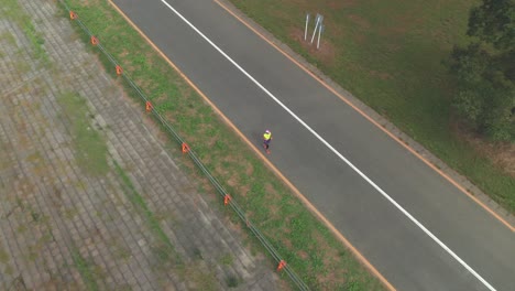 Aerial-View-Of-A-Japanese-Woman-Jogging-Alone-On-The-Street-In-Saitama,-Japan---drone-shot