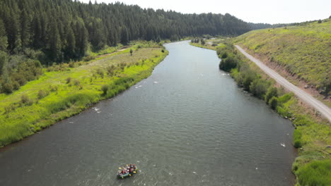 Pan-Up-Fly-over-drone-footage-of-driftboat-along-Henry's-Fork-Snake-River-in-southeastern-Idaho,-USA