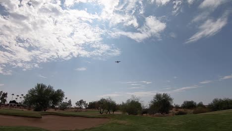 A-single-engine-airplane-flies-directly-over-the-golf-course-sand-trap,-Scottsdale,-Arizona