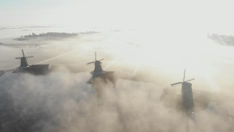 Enthüllung-Einer-Aufnahme-Von-4-Windmühlen-In-Einer-Reihe-An-Einem-Nebligen-Morgen-In-Den-Niederlanden-Bei-Der-Zaanse-Schans,-Filmische-Drohnenaufnahme-In-4K
