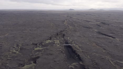 Aerial-of-barren-black-landscape-with-volcanic-surface-in-Iceland-at-peninsula